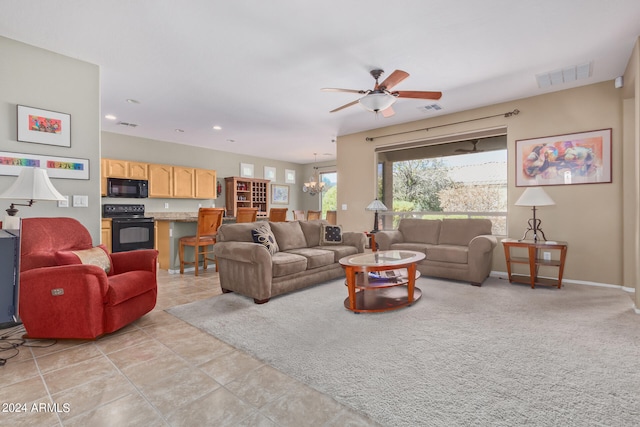 tiled living room with ceiling fan with notable chandelier