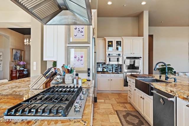 kitchen with white cabinets, stainless steel appliances, light stone countertops, and sink