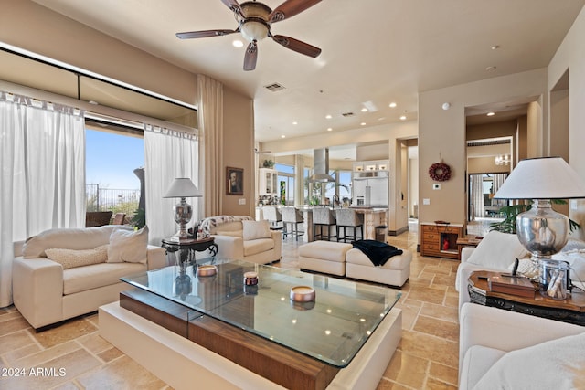 living room featuring ceiling fan and a healthy amount of sunlight