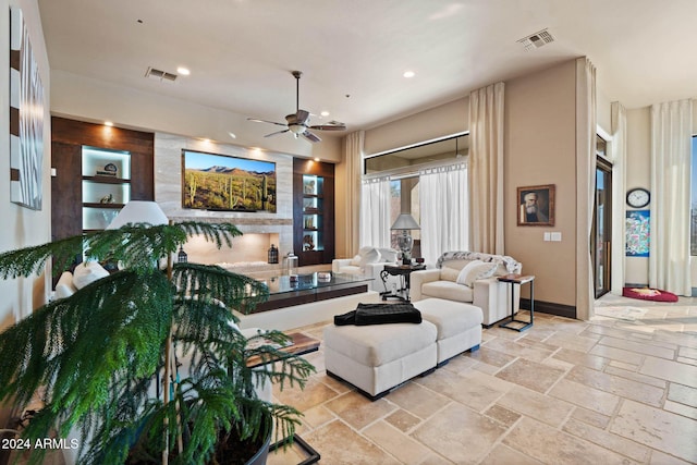 2549 W Shinnecock Way, Anthem, AZ 85086 - living area featuring a ceiling fan, stone tile flooring, built in features, recessed lighting, and baseboards