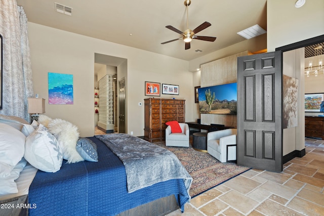 bedroom with ensuite bathroom and ceiling fan with notable chandelier