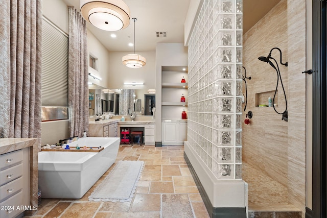 bathroom featuring vanity and independent shower and bath