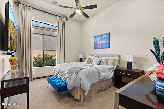 bedroom featuring multiple windows, ceiling fan, and light carpet