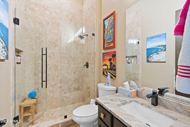 bathroom featuring tiled shower, vanity, and toilet