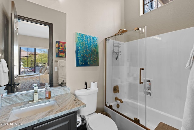 full bathroom with shower / bath combination with glass door, vanity, and toilet