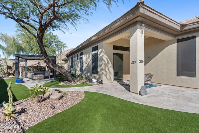 back of house with a pergola, a patio area, and a hot tub