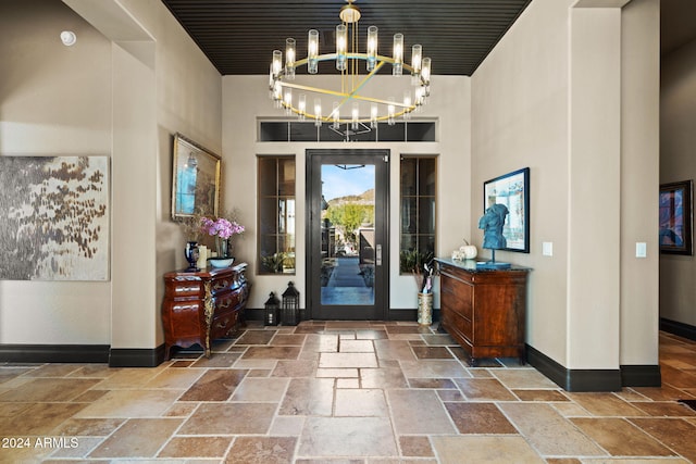 entryway with a towering ceiling and a notable chandelier