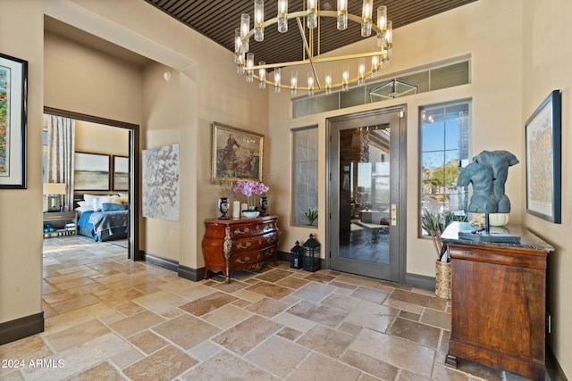 foyer featuring wood ceiling, a high ceiling, and a chandelier