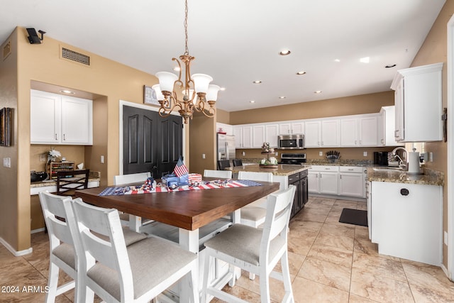 dining room featuring sink and a chandelier