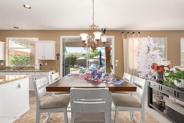 tiled dining room featuring a chandelier and sink