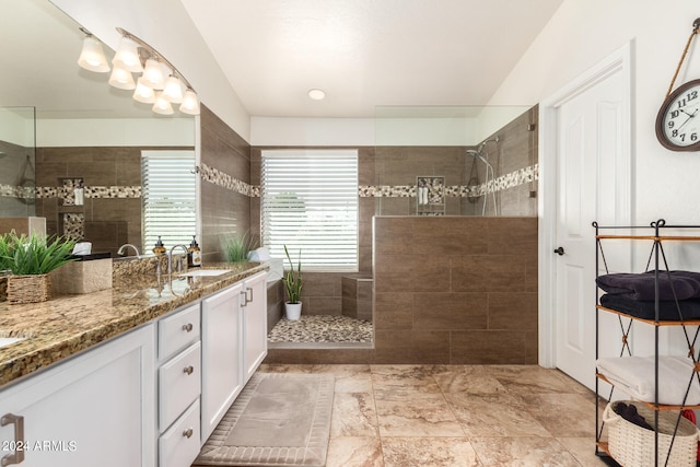 bathroom featuring tiled shower and vanity