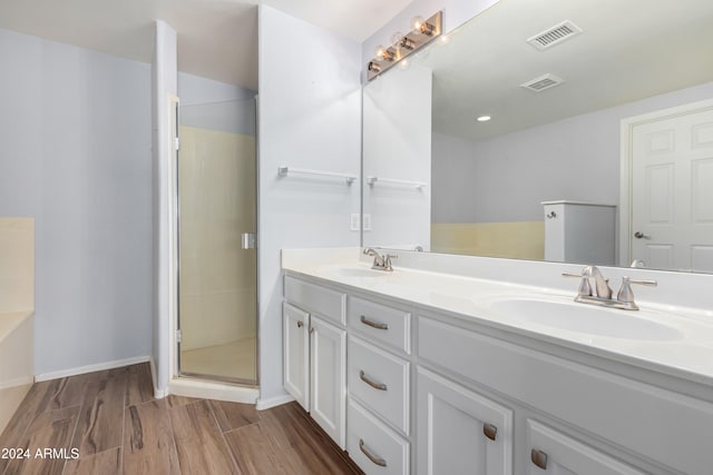 bathroom featuring vanity, separate shower and tub, and hardwood / wood-style floors