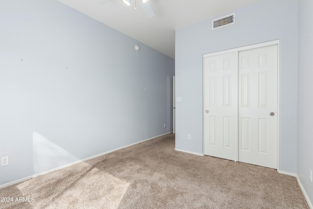 unfurnished bedroom with a closet, carpet flooring, and ceiling fan