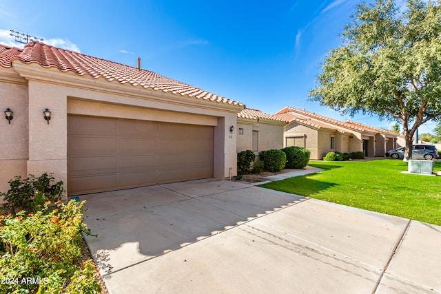 mediterranean / spanish-style house featuring a front lawn and a garage