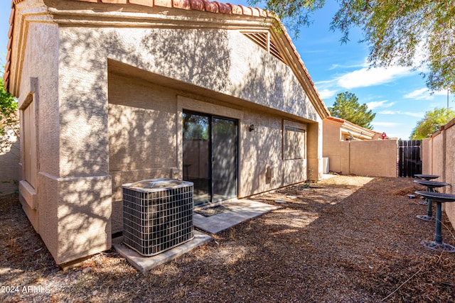 rear view of house featuring central air condition unit