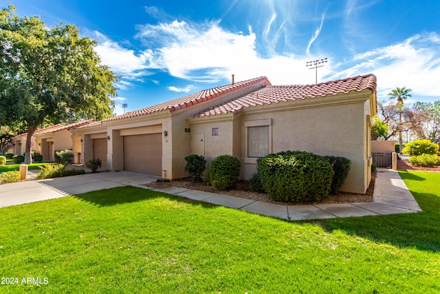 mediterranean / spanish-style home with a front yard and a garage