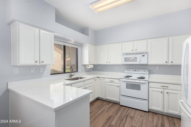 kitchen featuring dark hardwood / wood-style floors, kitchen peninsula, sink, white cabinets, and white appliances