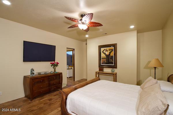 bedroom with ceiling fan and dark hardwood / wood-style floors