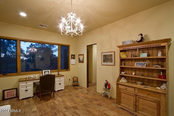 office featuring hardwood / wood-style floors and an inviting chandelier