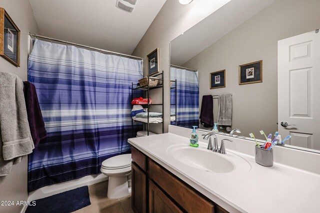 bathroom featuring vanity, lofted ceiling, a shower with shower curtain, toilet, and tile patterned floors