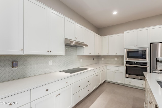 kitchen with white cabinetry, decorative backsplash, and stainless steel appliances