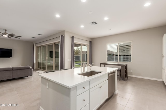 kitchen with white cabinetry, an island with sink, dishwasher, sink, and light tile patterned floors