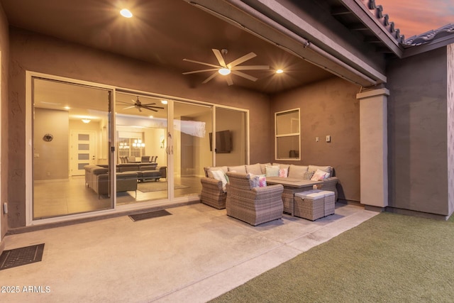 patio terrace at dusk featuring ceiling fan and outdoor lounge area