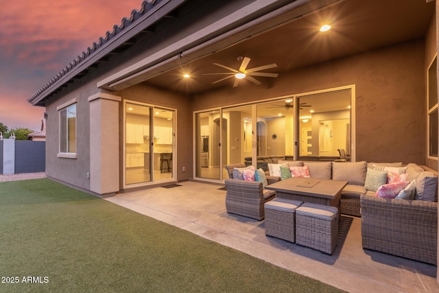 patio terrace at dusk featuring outdoor lounge area and ceiling fan