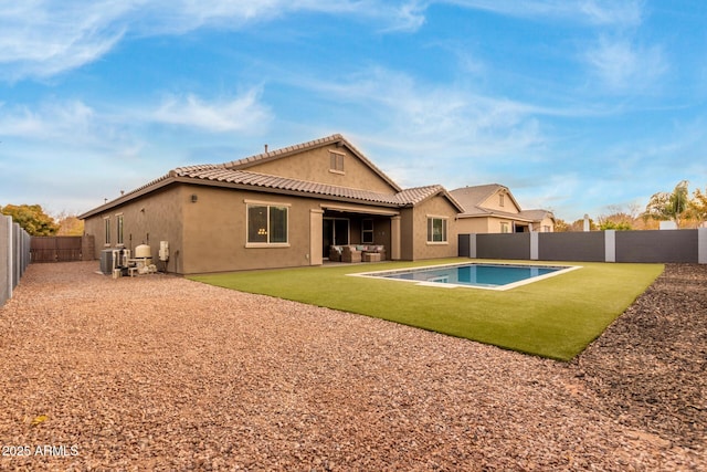 rear view of house with cooling unit, a fenced in pool, and a patio