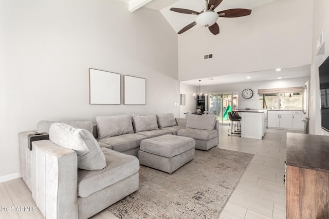 living room with ceiling fan, high vaulted ceiling, and beamed ceiling