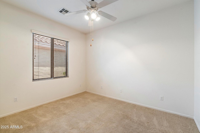 spare room featuring light colored carpet and ceiling fan