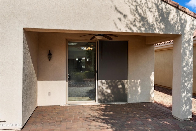 entrance to property with a patio area and ceiling fan