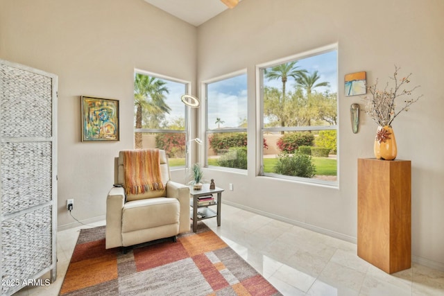 living area with tile patterned floors, baseboards, and plenty of natural light