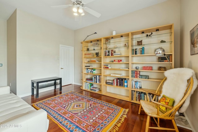 sitting room with baseboards, dark wood-type flooring, and ceiling fan