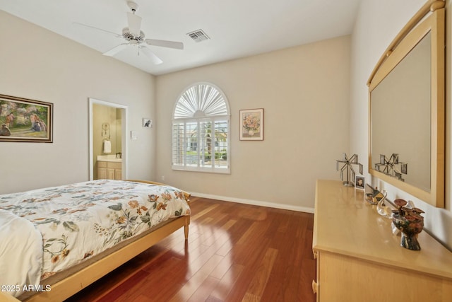 bedroom with a ceiling fan, wood finished floors, visible vents, baseboards, and ensuite bath