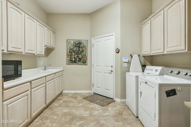 laundry room with a sink, baseboards, cabinet space, and washing machine and clothes dryer