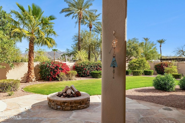 view of patio featuring an outdoor fire pit and fence