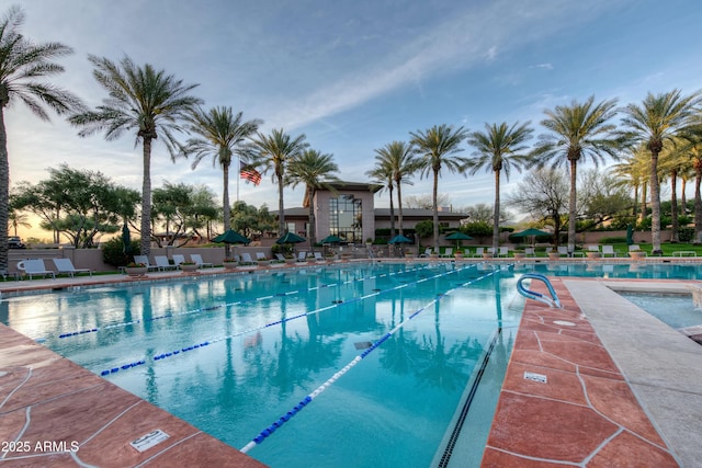 community pool with a patio and fence