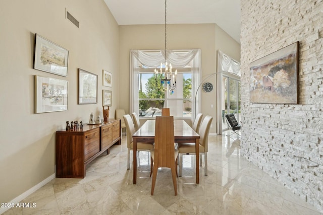 dining room with baseboards, visible vents, an inviting chandelier, a high ceiling, and marble finish floor