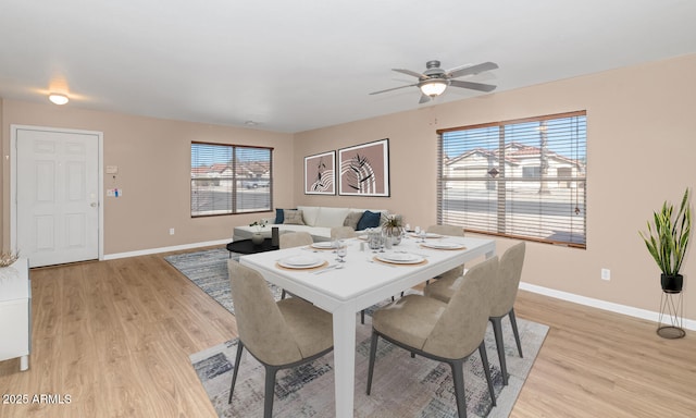 dining area with baseboards and light wood-style floors