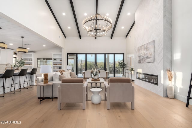 living room featuring light wood-type flooring, beam ceiling, a fireplace, high vaulted ceiling, and an inviting chandelier