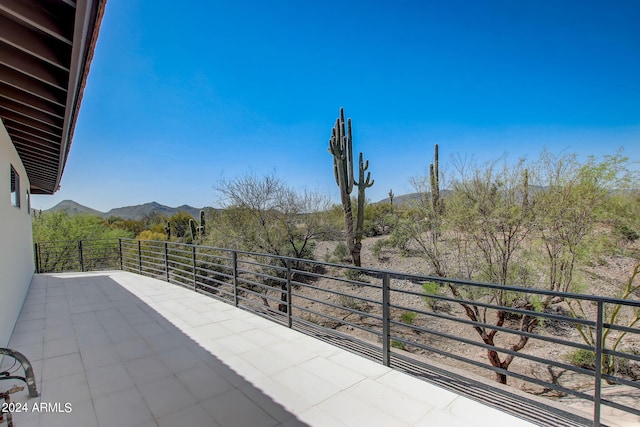 view of patio featuring a mountain view and a balcony