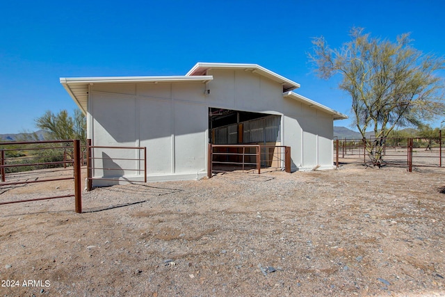 rear view of property with an outdoor structure and a rural view