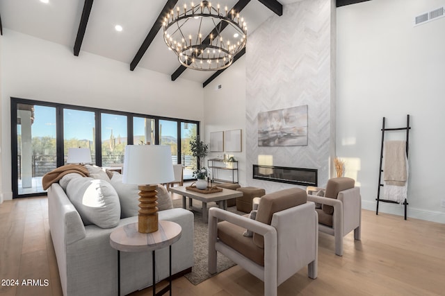 living room featuring a fireplace, a chandelier, and light hardwood / wood-style floors