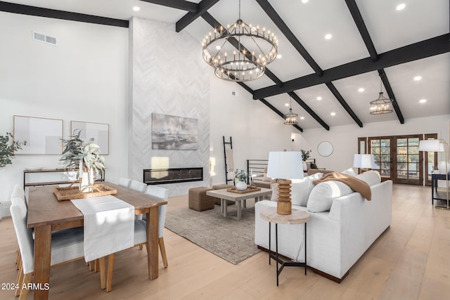 living room with light wood-type flooring, a fireplace, beam ceiling, and high vaulted ceiling