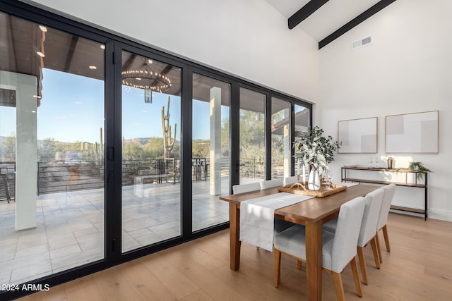 dining room featuring a chandelier, light hardwood / wood-style floors, and high vaulted ceiling