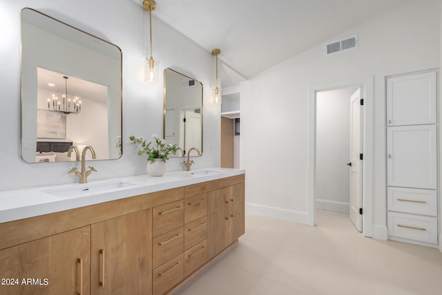 bathroom featuring an inviting chandelier, lofted ceiling, vanity, and tile patterned floors