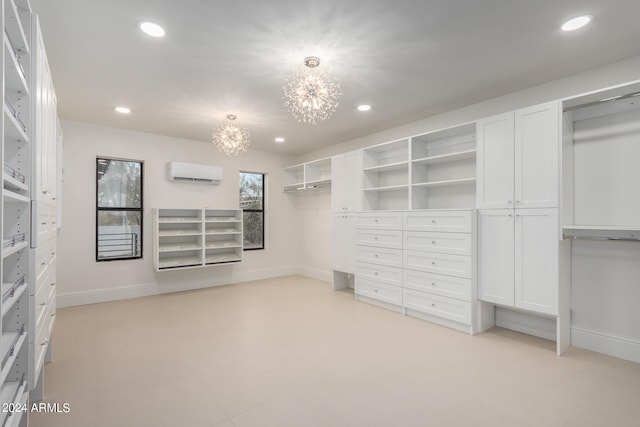 spacious closet featuring an inviting chandelier and an AC wall unit