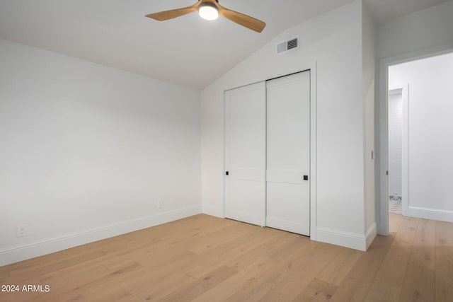 unfurnished bedroom featuring light hardwood / wood-style flooring, vaulted ceiling, a closet, and ceiling fan