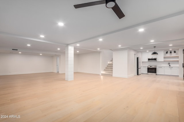 unfurnished living room featuring ceiling fan and light hardwood / wood-style flooring